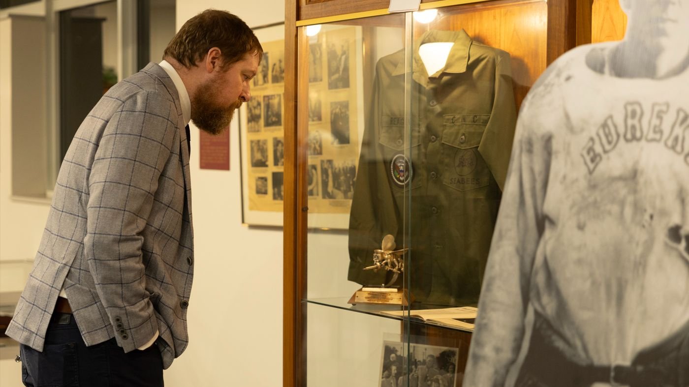 A visitor examines Reagan artifacts in a museum display case