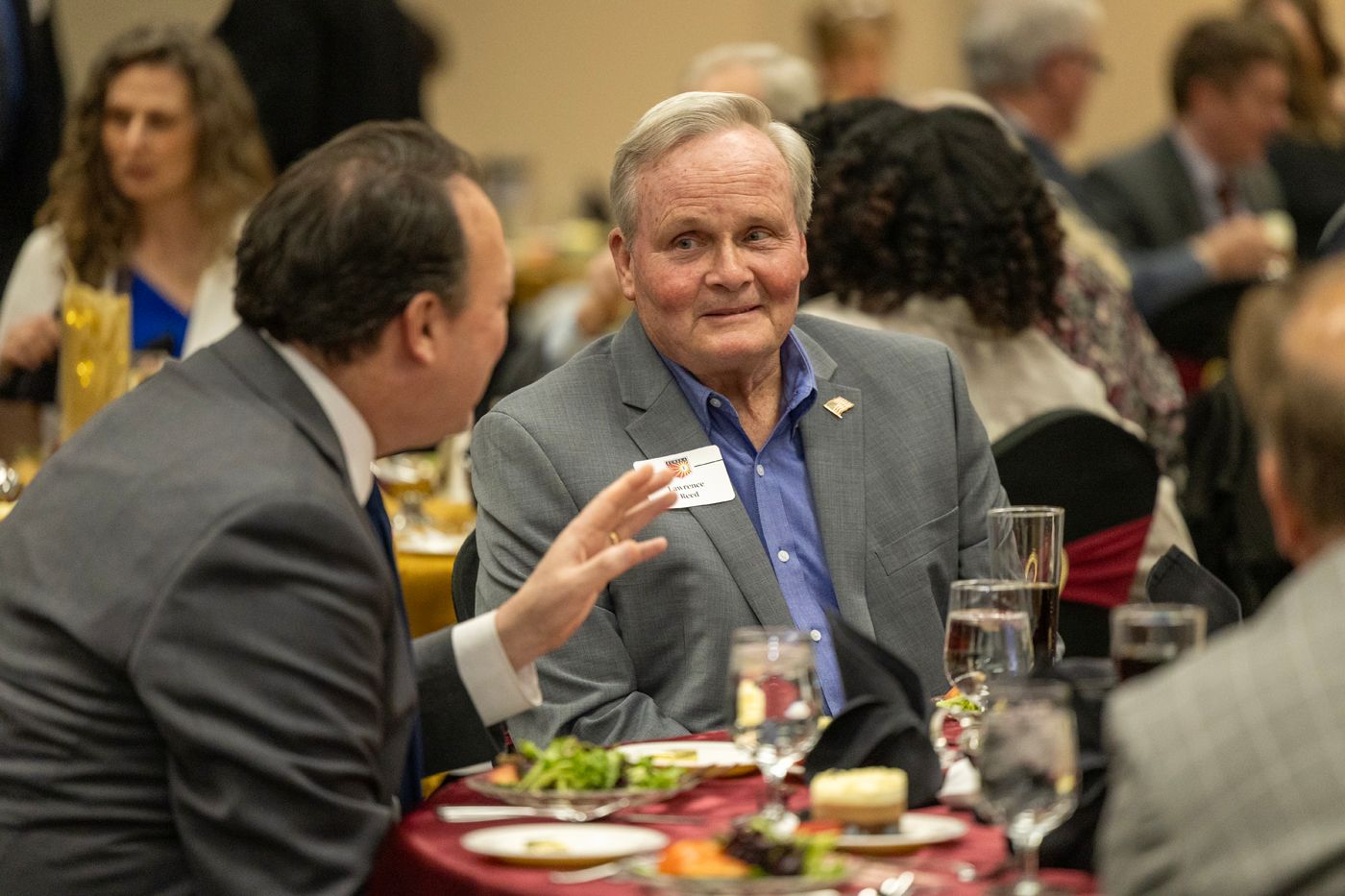 Alumni talking at table during event
